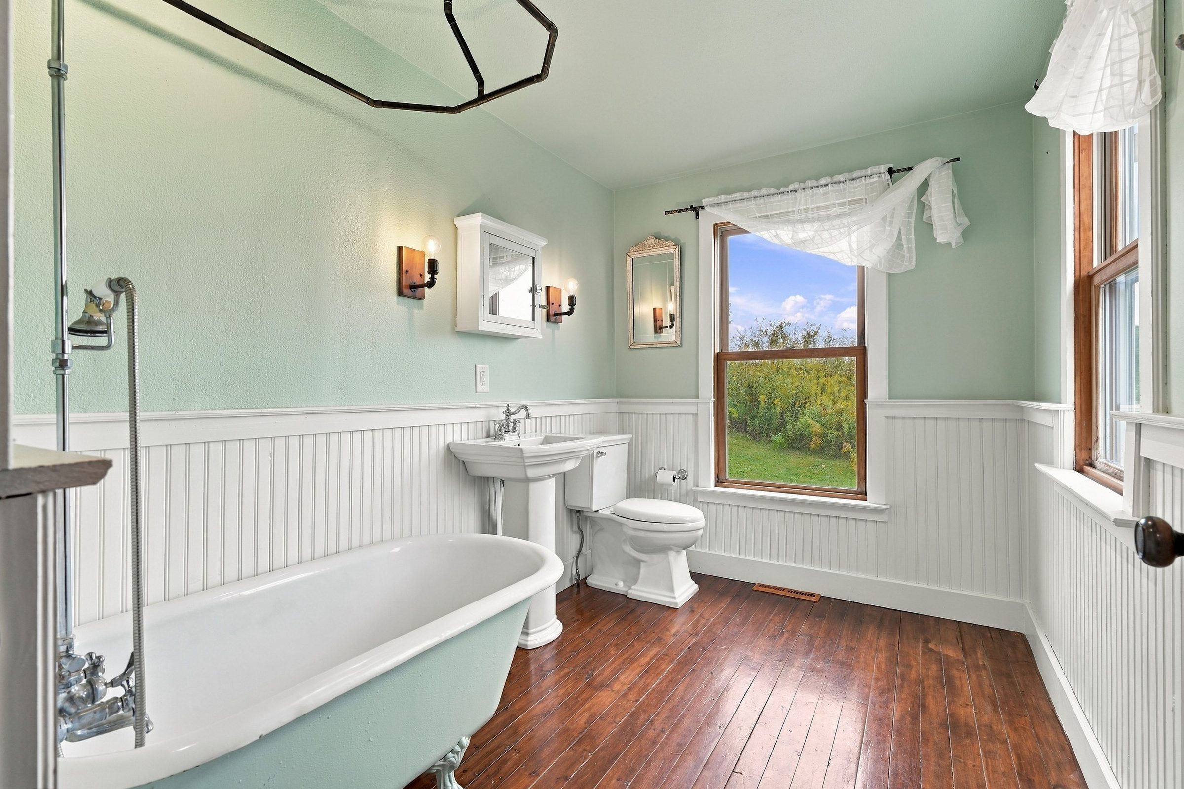 Bathroom with a clawfoot tub and green wainscoting